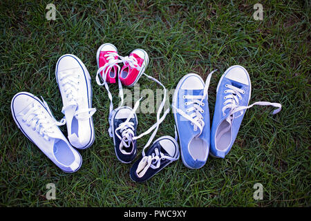 Quatre couleurs différentes paire d'espadrilles, chaussures pour toute la famille couché dans l'herbe Banque D'Images