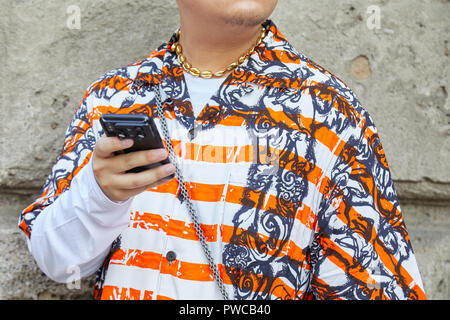 MILAN, ITALIE - 20 septembre 2018 : blanc et orange rayée chemise et collier or looking at smartphone avant Max Mara fashion show, M Banque D'Images