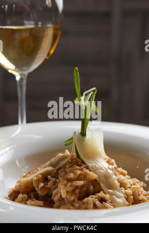 Plat italien risotto aux champignons sauvages et parmesan dans une assiette blanche. Banque D'Images