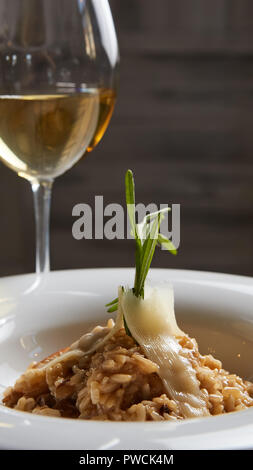 Plat italien risotto aux champignons sauvages et parmesan dans une assiette blanche. Banque D'Images