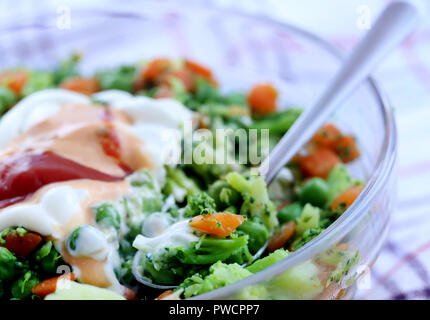 Salade de légumes frais avec la sauce vinaigrette dans un bol en verre Banque D'Images