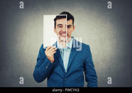 Portrait of a sad woman la moitié de son visage à l'aide d'une feuille photo portrait avec un faux professionnels de l'émotion. Masque pour cacher le vrai visage d'expression, c Banque D'Images
