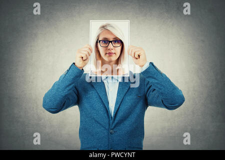 Utiliser un businessman woman portrait comme agent secret, cachant son visage derrière feuille photo, comme un faux masque. La vie privée, de dédoublement de personnalité et l'irréel ident Banque D'Images