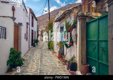 Belle vue sur ruelle pittoresque avec des maisons traditionnelles fleurs colorées et rue pavée, dans un village de Crète. Banque D'Images