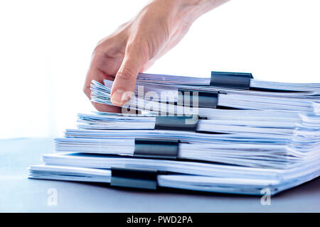 Les mains de toucher le papier de bureau. Les fichiers documents piles noir avec clip. Banque D'Images