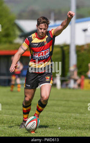 Image de joueur de rugby en tenant lieu d'un coup de pied dans la lumière du soleil. Banque D'Images