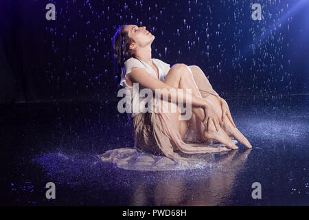 Fille assise sous la pluie, nuit concept. Style mystique Banque D'Images