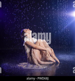 Fille assise sous la pluie, nuit concept. Style mystique Banque D'Images