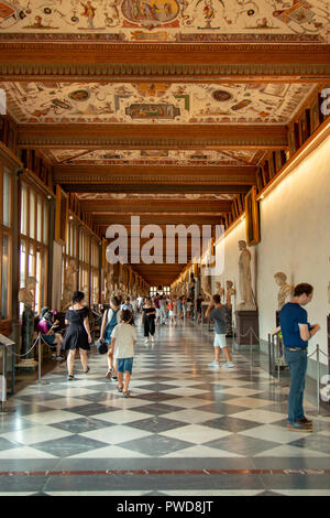 La ligne de touristes long couloir d'admirer des œuvres d'art dans la galerie des Offices à Florence, Italie. Banque D'Images