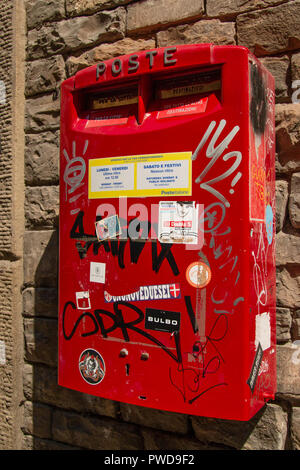 Une boîte postale rouge couverts de graffitis à Florence, Italie Banque D'Images