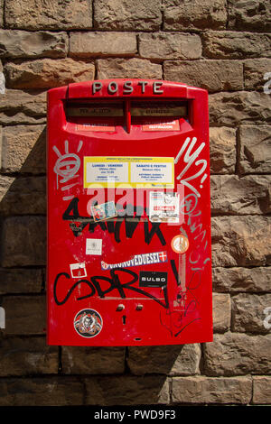 Une boîte postale rouge couverts de graffitis à Florence, Italie Banque D'Images