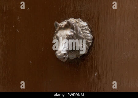 Une porte en forme de tête de cheval tirer sur une porte en bois brun à Florence, Italie. Banque D'Images