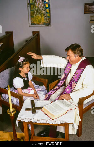 Prêtre catholique bénédiction enfant avec plus de main tête de l'enfant au cours de la réconciliation. © Myrleen ....Pearson Ferguson Cate Banque D'Images