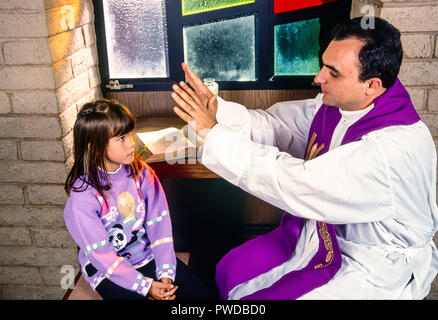 Prêtre catholique bénédiction enfant avec plus de main tête de l'enfant au cours de la réconciliation. © Myrleen ....Pearson Ferguson Cate Banque D'Images