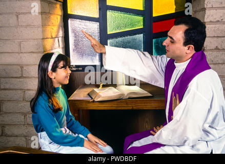 Prêtre catholique bénédiction enfant avec plus de main tête de l'enfant au cours de la réconciliation. © Myrleen ....Pearson Ferguson Cate Banque D'Images