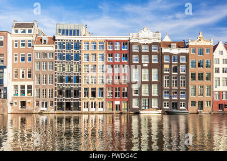 Maisons d'Amsterdam Damrak sur un canal partiellement remplies au dancing maisons avec l'architecture néerlandaise par le canal Amsterdam Hollande Pays-bas eu Europe Banque D'Images