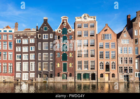 Maisons d'Amsterdam Damrak sur un canal partiellement remplies au dancing maisons avec l'architecture néerlandaise par le canal Amsterdam Hollande Pays-bas eu Europe Banque D'Images