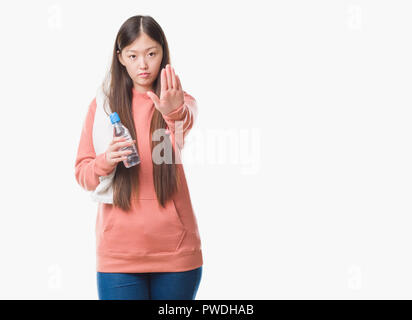 Jeune femme chinoise sur fond isolé portant des sweathshirt sport avec main ouverte faisant stop avec de sérieux et de confiance, la défense de l'expression g Banque D'Images