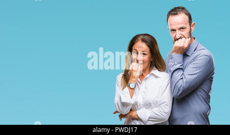 L'âge moyen hispanic business couple fond isolé à souligné et nerveux avec les mains sur la bouche de mordre les ongles. Problème d'anxiété. Banque D'Images