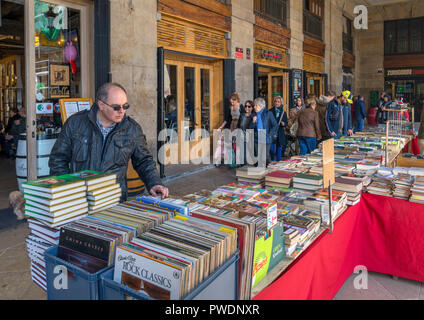 Man looking at second hand books et vinyle LP records sur une échoppe de marché sur la Plaza Nueva, Casco Viejo, Bilbao, Pays Basque, Espagne Banque D'Images