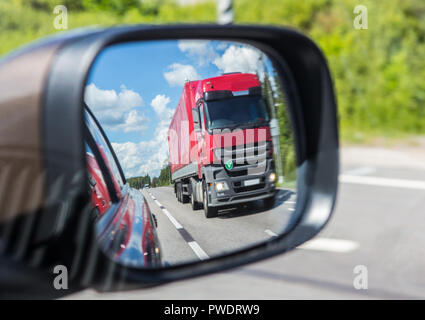 Camion rouge reflet dans un miroir de voiture Banque D'Images