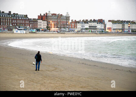 Weymouth. 15 octobre 2018. Un homme solitaire promène son chien sur terne et sables de la bruine tôt le matin Crédit : Stuart fretwell/Alamy Live News Banque D'Images