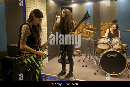 Antélias, Liban. 26 Sep, 2018. Sheryline Beshara (L), guitariste de tous les Libanais et les femmes Le groupe de heavy metal "esclaves de sirènes' ajuste ses accords de guitare avant de commencer une répétition avec le guitariste rythmique Lialas Mayassi (C) et le batteur Tatyana Boughaba. Credit : Marwan Naamani/afp/Alamy Live News Banque D'Images