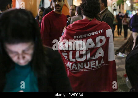 Sao Paulo, Brésil. 15 Oct, 2018. 15 octobre 2018, au Brésil, Sao Paulo : un homme porte un drapeau avec l'inscription 'président Haddad, Lula et Manuela'. Deux semaines et demie avant le deuxième vote au Brésil, les sondeurs voir le populiste de droite candidate présidentielle dans Bolsonaro un avantage évident. En conséquence, 42  % des électeurs veulent voter pour Haddad. Credit : Warley Kenji/dpa/Alamy Live News Banque D'Images