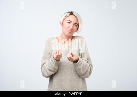 Portrait de femme intense, perplexe fronçant et montrant l'italien geste avec la main, de poser la question au cours des plaidoiries Banque D'Images