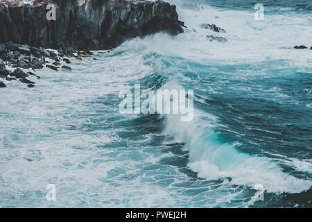 Vagues qui coastling - falaise noire sur la côte de l'océan Banque D'Images