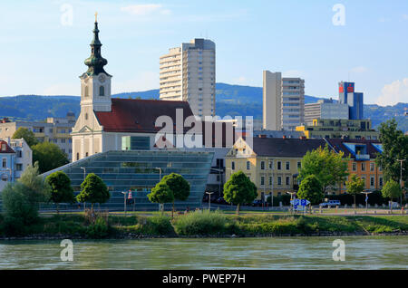 L'Autriche, Haute Autriche, Linz sur le Danube, capitale de la province de Haute-Autriche, capitale européenne 2009, vue sur la ville de Linz-Urfahr, église paroissiale Saint-Joseph, église catholique, derrière complexe architectural Lentia 2000, les tours d'habitation, maisons résidentielles, publicités, rive du Danube, riverwalk Banque D'Images