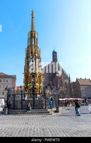 Le 14e siècle Schöner Brunnen fontaine sur la place principale de Nuremberg, Allemagne. Derrière se dresse l'église Frauenkirche. Banque D'Images