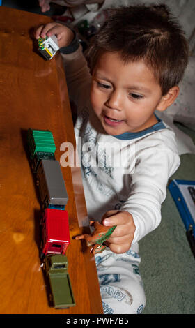 L'âge pré-scolaire Hispanic boy playing with miniature train le matin de Noël. M. © Myrleen Pearson ...Ferguson Cate Banque D'Images