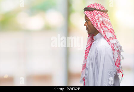 Jeune arabe african man wearing keffieh traditionnel sur fond isolé à côté de beauté, posent avec profil visage naturel avec certain sm Banque D'Images