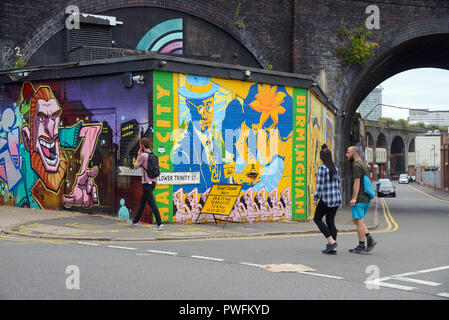 Jeune couple & Man passer devant l'Art de rue dans le vieux Run-Down Rues de Digbeth Birmingham England Banque D'Images