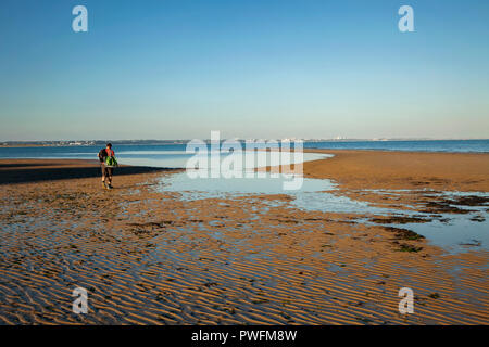 Ondulations dans le sable à la plage Studland, Dorset. Prises au crépuscule à marée basse avec l'homme à marcher en direction de l'eau Banque D'Images