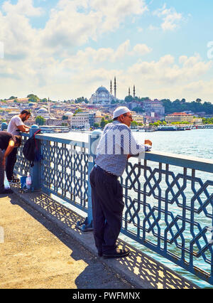 Un citoyen sur le pont de Galata à regarder un ferry traversant la baie de la Corne d, et une vue sur le quartier d'Eminonu en arrière-plan. Istanbul. Banque D'Images
