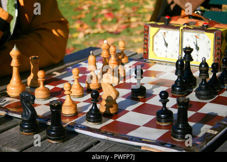 Deux hommes jouer aux échecs en plein air dans un parc sur une table en bois. Close up. Seules les mains peuvent être vu Banque D'Images