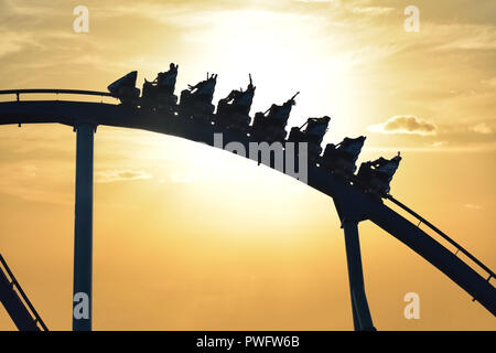 Orlando, Floride. 21 septembre, 2018. Funny People riding Mako Rollercoaster à Seaworld sur beau fond coucher de soleil. Banque D'Images