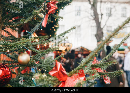 L'arbre de Noël ou des branches de sapin au premier plan. Le marché de Noël en Allemagne est flou en arrière-plan. Locations de. Se détendre pendant les vacances. Banque D'Images