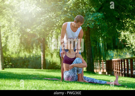 Longueur totale shot of young woman practicing yoga avec son instructeur. Banque D'Images