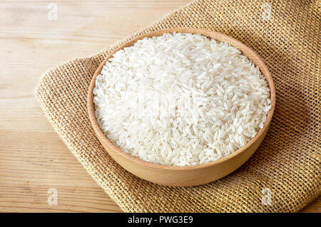 Cru, le riz étuvé dans un bol en bois. Plat de riz sur une table en bois, le régime alimentaire ou d'une saine alimentation. Banque D'Images