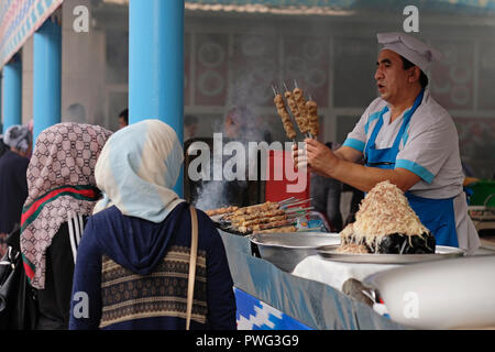 Un vendeur vendant des kebab grillés sur des brochettes dans le bazar Chorsu également appelé bazar Charsu situé dans le centre de la vieille ville de Tachkent capitale de l'Ouzbékistan Banque D'Images