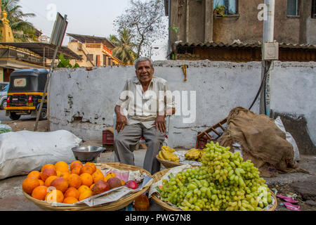 L'Inde, Uttar Pradesh, Varanasi, happy smiling mature vendeur de rue vendant des fruits sur le marché Banque D'Images