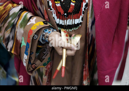 Le port de Vêtement femme ouzbèke traditionnelle de la région de Surkhandarya près de la frontière sud du Tadjikistan à l'aide de cuillères en bois pour percussions au cours de la cuillère la danse. L'Ouzbékistan Banque D'Images