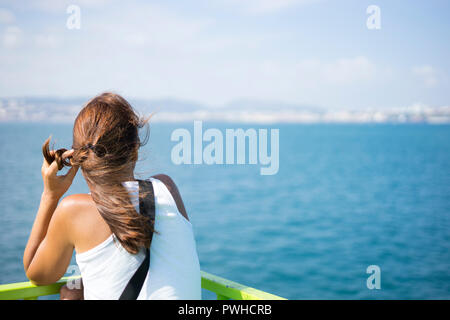 Jeune femme sur le ferry en direction de sa destination à l'horizon Banque D'Images