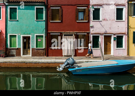 Maisons colorées traditionnelles reflétant dans le canal avec de petits bateaux dans l'île de Burano, Venise, Italie Banque D'Images