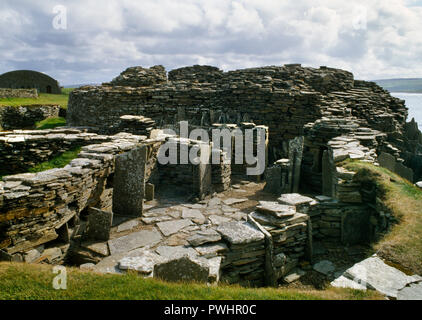 Voir s de maisons construites plus tard autour de Midhowe broch de l'âge du Fer (centre arrière de la tour) sur la côte sud de l'île de Rousay, Orkney, Scotland, UK. Banque D'Images