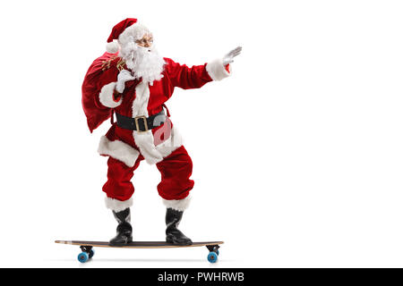 Profil de pleine longueur tourné du Père Noël équitation un longboard isolé sur fond blanc Banque D'Images