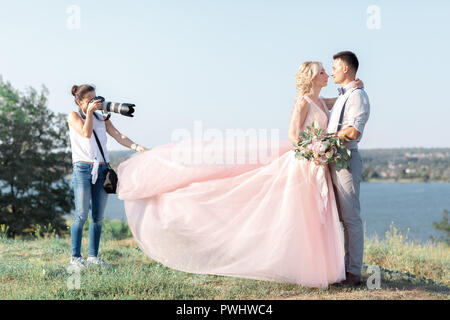 Photographe de mariage prend des photos de jeunes mariés Banque D'Images
